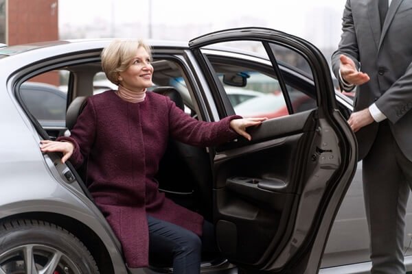 Chauffeur Services in St. Moritz. Chauffeur opening the door for the client