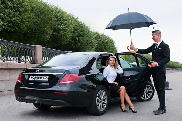 Private chauffeur Engelberg opening the vehicle door to client